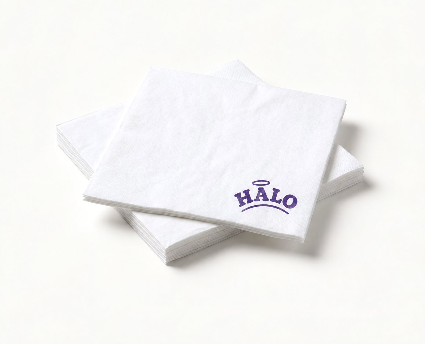 Stack of white 30 cm napkins printed with the purple “HALO” logo